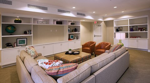 a living room with a couch and chairs and a book shelf